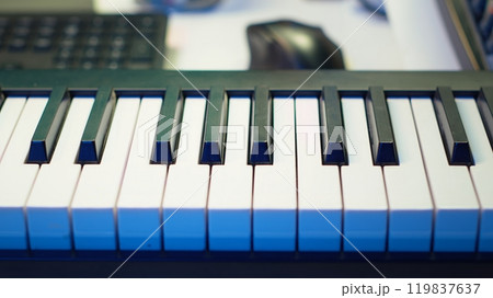 Electronic piano keyboard with mixing console at home studio used for producing tunes and soundtracks, acoustical engineering devices for music production. Empty desk with synthesizer device. 119837637