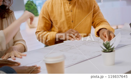 Realtor and clients exploring an urban property financial potential, evaluating architectural blueprints and negotiating leasing contract terms for a high class corporate office space. Camera A. 119837645