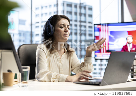 Young female entrepreneur having fun listening to her favorite music, dancing around in her high end corporate office. Director with executive power multitasking, working and singing. 119837693