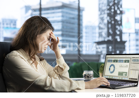 Frustrated financial banker analyzing investment insights and trading risks before spending money for company development. Evaluating data analytics and budget reports, tired CEO. Frustrated financial banker analyzing investment insights and trading risks before spending money for company development. Evaluating data analytics and budget reports, tired CEO. 119837720
