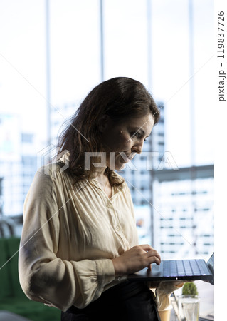 Determined female entrepreneur oversees a strategic review of the company activity, analyzing market trends and setting new priorities. Ensuring the enterprise objectives achievements. Determined female entrepreneur oversees a strategic review of the company activity, analyzing market trends and setting new priorities. Ensuring the enterprise objectives achievements. 119837726