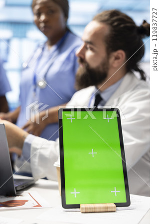 Licensed doctor and his staff review x ray scan results next to isolated copy space screen, examining hospital records before putting a diagnosis. Consulting analytics and radiography. Licensed doctor and his staff review x ray scan results next to isolated copy space screen, examining hospital records before putting a diagnosis. Consulting analytics and radiography. 119837727