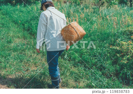 山で収穫かごをさげている若い女性 119838783