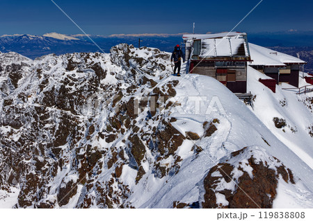 厳冬の八ヶ岳連峰・赤岳山頂を行く登山者と浅間山・谷川連峰の眺め 厳冬の八ヶ岳連峰・赤岳山頂を行く登山者と浅間山・谷川連峰の眺め 119838808