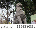 青空の下で邪気を払うように咆哮する神社の狛犬（阿形）の石像 119839381