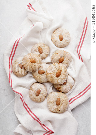 Italian almond cookies coated in powdered sugar, top view of round delicious biscuits styled on white napkin, paste di mandorle 119843568