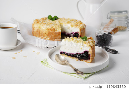 A pies of cottage cheese pie with crumbs and filler from frozen berries and mint and cup of tea. Seasonal food 119843580