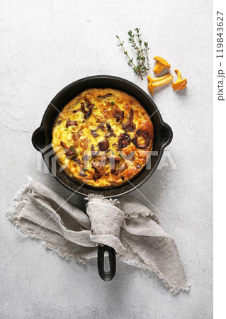 Healthy breakfast, omelette with fried seasonal forest mushrooms Chanterelles in frying pan on a light background, top view Healthy breakfast, omelette with fried seasonal forest mushrooms Chanterelles in frying pan on a light background, top view 119843627