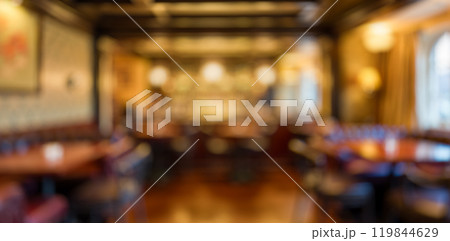 Blurred pub interior, warm lighting, cozy atmosphere, empty wooden tables and chairs, inviting space for gatherings, social events background Blurred pub interior, warm lighting, cozy atmosphere, empty wooden tables and chairs, inviting space for gatherings, social events background 119844629