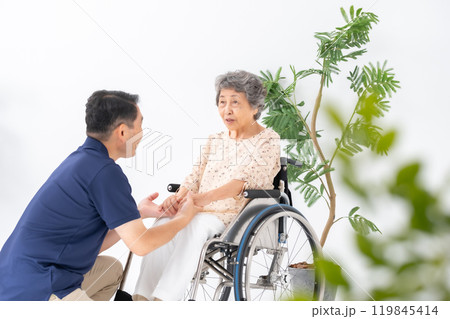 車いすのシニア女性と男性介護士 119845414