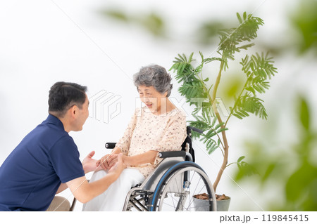 車いすのシニア女性と男性介護士 119845415
