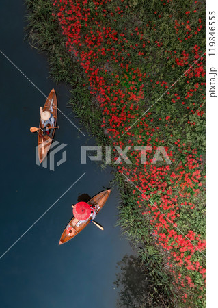 土手に咲く彼岸花と船を漕ぐ船頭 119846555