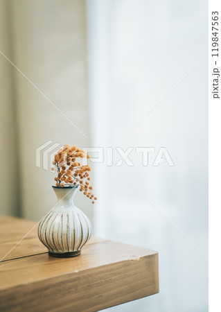 テーブルの上に置いた一輪挿しのミモザのドライフラワー テーブルの上に置いた一輪挿しのミモザのドライフラワー 119847563