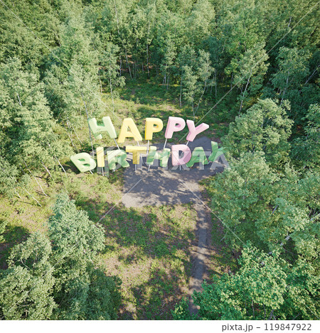A large Happy Birthday message made of 3D letters in a forest 119847922