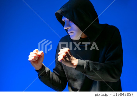 仮面を着けて構える男性 119848857