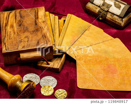 deck of medieval italian board playing cards with blank and white card, on the table along with coins and wooden card holder 119848917
