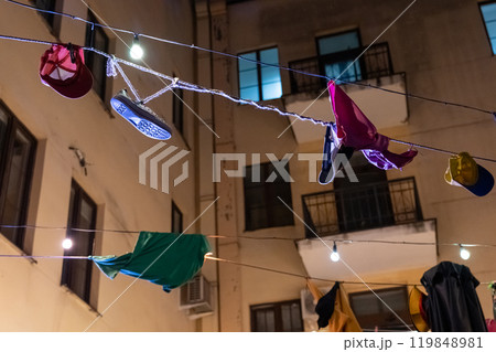 Underwear and clothes hang on ropes above the bar at night 119848981
