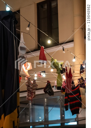 Underwear and clothes hang on ropes above the bar at night 119848982