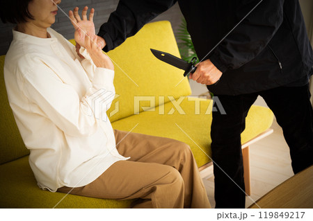 ナイフを持つ強盗と怯えるシニア女性 119849217