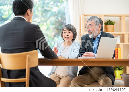 シニア夫婦に説明する営業マン　遺産相続について相談するシニア夫婦 119849395