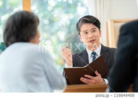 シニア夫婦に説明する営業マン 遺産相続について相談するシニア夫婦 シニア夫婦に説明する営業マン 遺産相続について相談するシニア夫婦 119849400