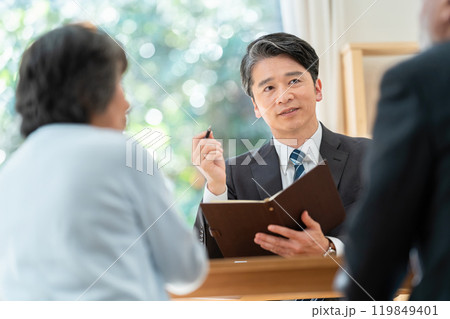 シニア夫婦に説明する営業マン　遺産相続について相談するシニア夫婦 119849401