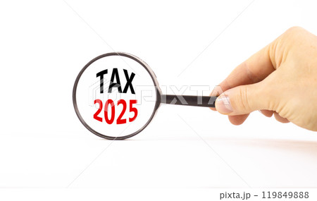 Planning tax 2025 new year symbol. Concept words Tax 2025 on beautiful white paper in magnifying glass. Businessman hand. Beautiful white background. Business tax 2025 new year concept. Copy space. 119849888