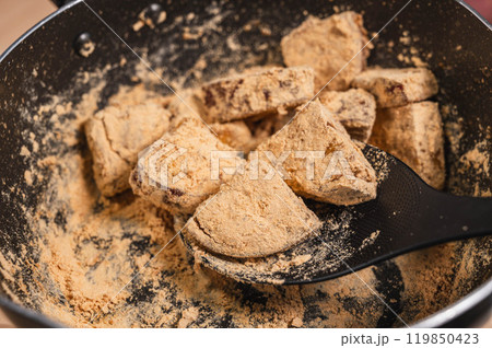 さつまいもの煮物にきな粉をまぶす さつまいもの煮物にきな粉をまぶす 119850423