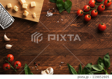 Frame of Italian ingredients on a rustic wooden background, fresh tomatoes, basil, garlic and parmesan cheese. Space for your text. 119852605