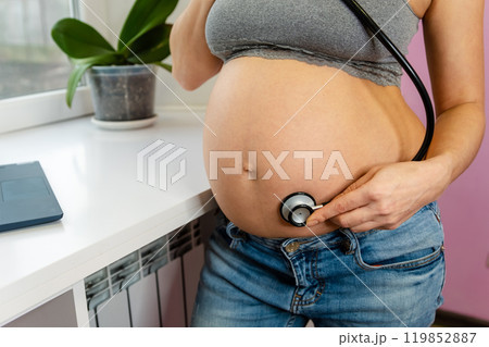 An expectant mother in a serene home environment engages An expectant mother in a serene home environment engages 119852887