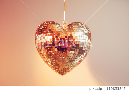 Heart shaped disco ball. Valentine's Day, love symbol and romantic exclusive relationships concept. Party decorations and dancing in nightclub theme. Heart-shaped discoball hanging from the ceiling 119853845