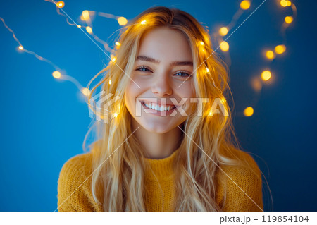 Happy young woman with glowing light strings around her head, a concept of mindfulness, meditation, creativity inspiration. Cozy home Christmas time, decorative Christmas twinkling string lights 119854104
