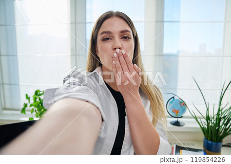 Close-up selfie portrait of young cheerful woman looking at web camera Close-up selfie portrait of young cheerful woman looking at web camera 119854226