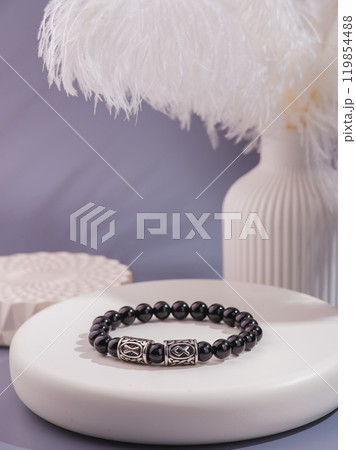Woman's wrist wearing orange agate bracelet, isolated on white background. 119854488