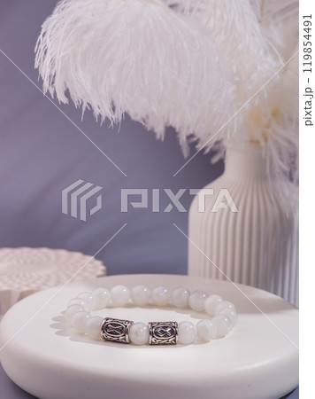 Woman's wrist wearing orange agate bracelet, isolated on white background. Woman's wrist wearing orange agate bracelet, isolated on white background. 119854491