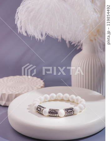 Woman's wrist wearing orange agate bracelet, isolated on white background. 119854492