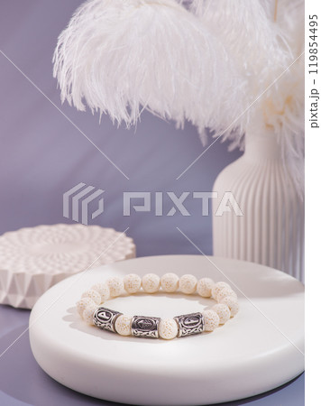 Woman's wrist wearing orange agate bracelet, isolated on white background. 119854495