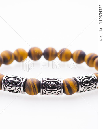 A charming double bracelet in shades of pink, made from natural stone and set against a gray background. The heart charm with cubic zirconia stands out in this close-up top view 119854529