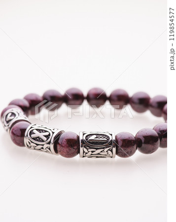 A charming double bracelet in shades of pink, made from natural stone and set against a gray background. The heart charm with cubic zirconia stands out in this close-up top view A charming double bracelet in shades of pink, made from natural stone and set against a gray background. The heart charm with cubic zirconia stands out in this close-up top view 119854577