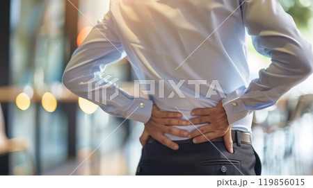 Office worker experiencing lower back pain, Poor posture can lead to back pain, backache, Lumbago 119856015