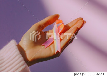 Delicate Pink Ribbon Held in Soft Woman's Hand Delicate Pink Ribbon Held in Soft Woman's Hand 119856441