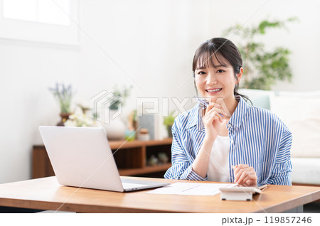 笑顔で確定申告の準備をする若い女性 笑顔で確定申告の準備をする若い女性 119857246