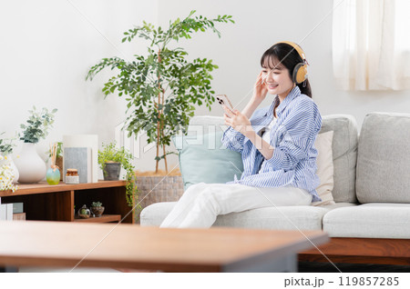 リビングで音楽を聴く若い女性 119857285