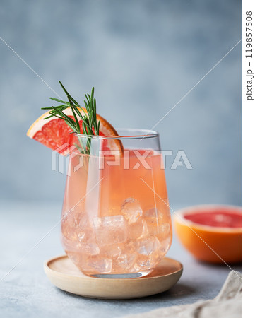 Homemade grapefruit lemonade with rosemary and ice in a glass on a blue background with fresh citrus 119857508