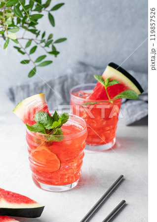 Watermelon mojito cocktail with lime, ice and mint in a two glasses on a blue background Watermelon mojito cocktail with lime, ice and mint in a two glasses on a blue background 119857526