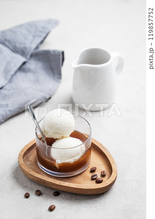 Affogato coffee with vanilla ice cream scoops and espresso in a glass on a wooden board Affogato coffee with vanilla ice cream scoops and espresso in a glass on a wooden board 119857752