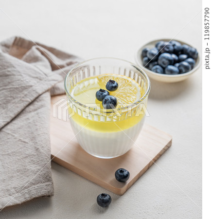 lemon panna cotta with blueberries in glass on a wooden board  on a light background with berries  119857790
