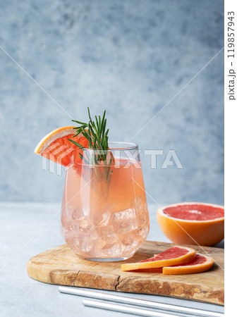 Grapefruit lemonade drink with rosemary and ice in a glass on a blue background Grapefruit lemonade drink with rosemary and ice in a glass on a blue background 119857943