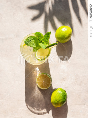 Lime mojito in a glass with mint and ice. Refreshing citrus cocktail on a light background Lime mojito in a glass with mint and ice. Refreshing citrus cocktail on a light background 119858042