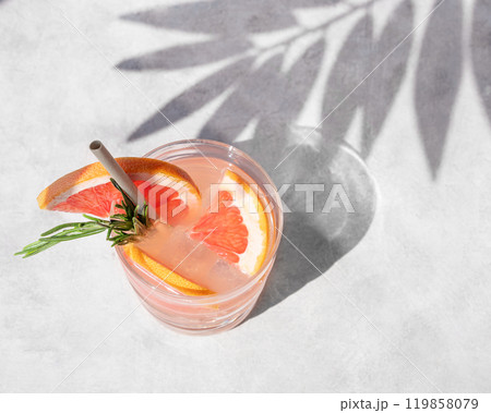 Grapefruit mojito cocktail with rosemary and ice in a glass on a light background Grapefruit mojito cocktail with rosemary and ice in a glass on a light background 119858079